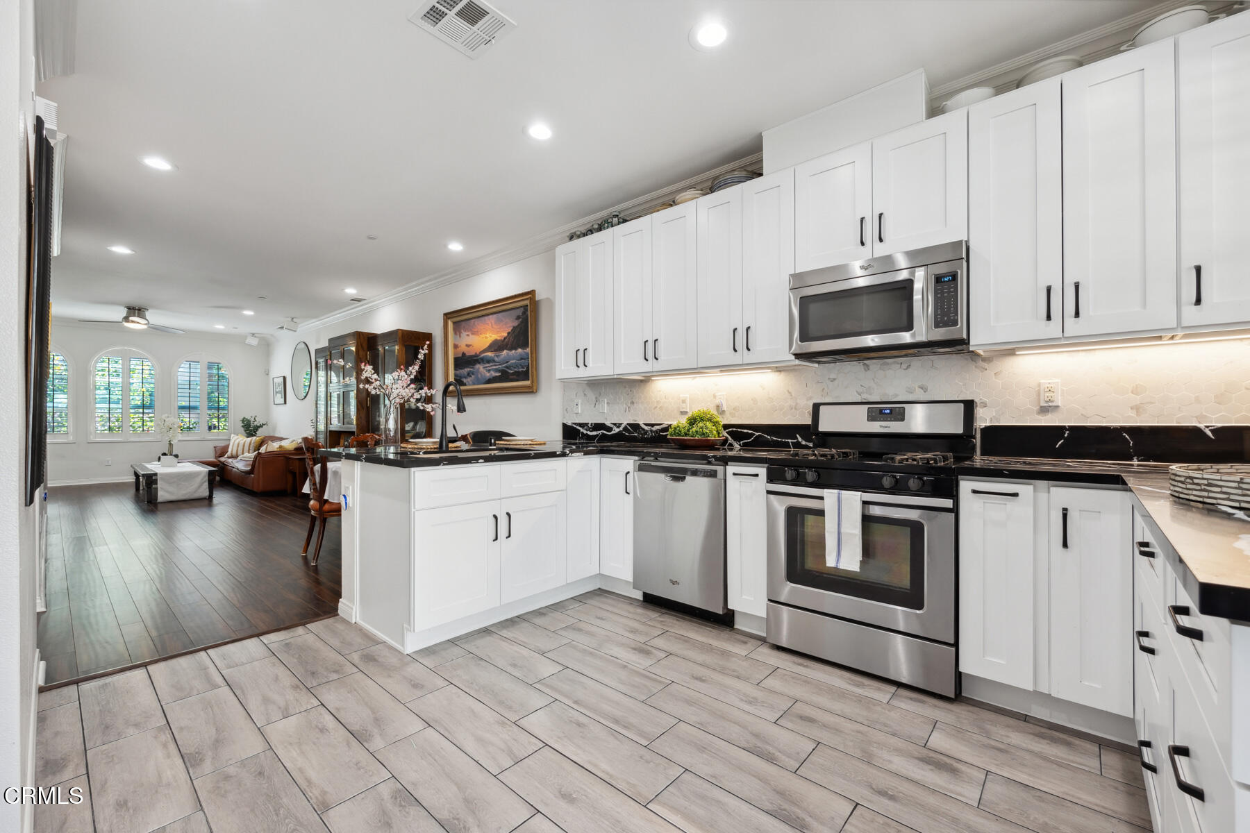 a kitchen with stainless steel appliances granite countertop a stove a sink and a microwave