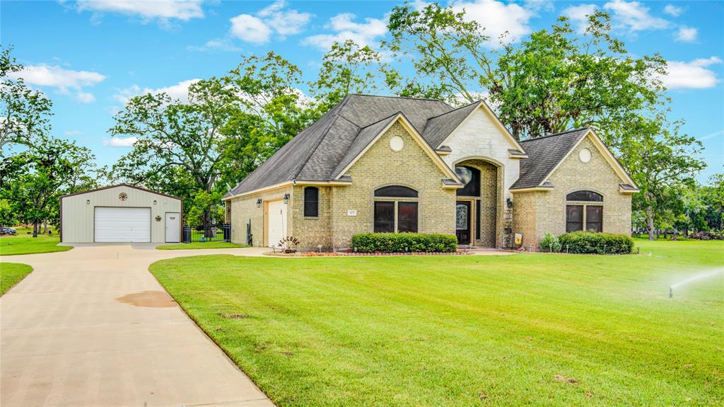 a front view of a house with yard and green space