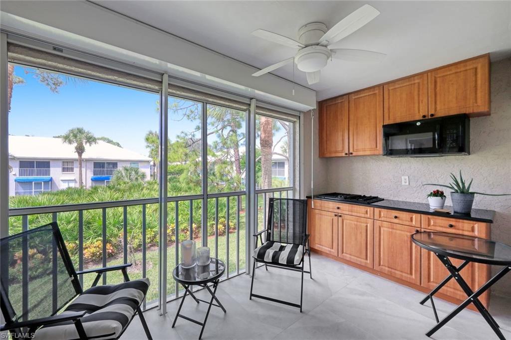 a kitchen with a table chairs microwave and cabinets