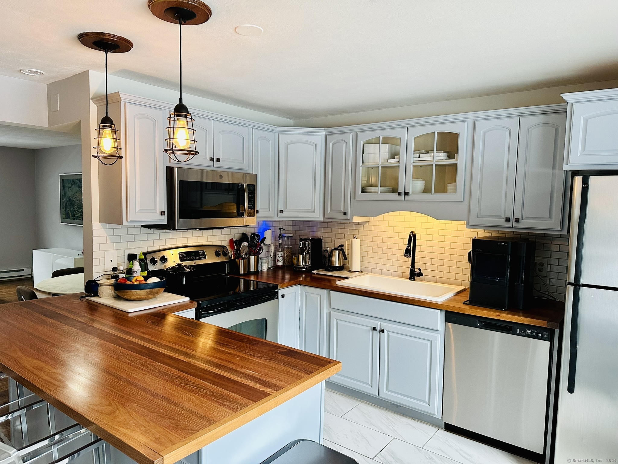 a kitchen with sink refrigerator and microwave