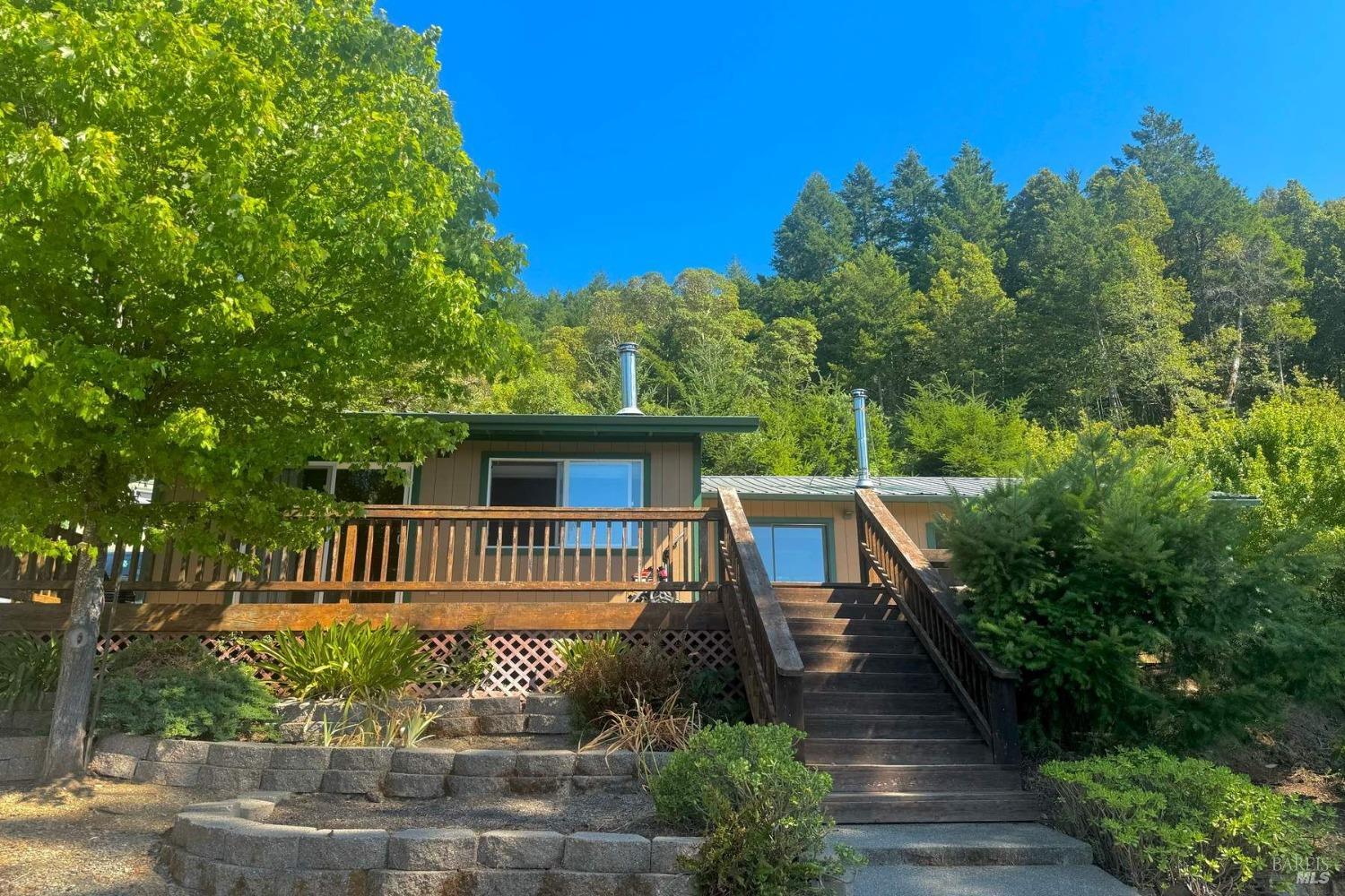 a view of a deck in front of house with trees