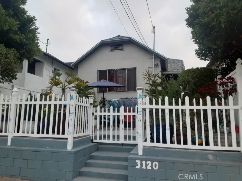 a view of a house with wooden fence