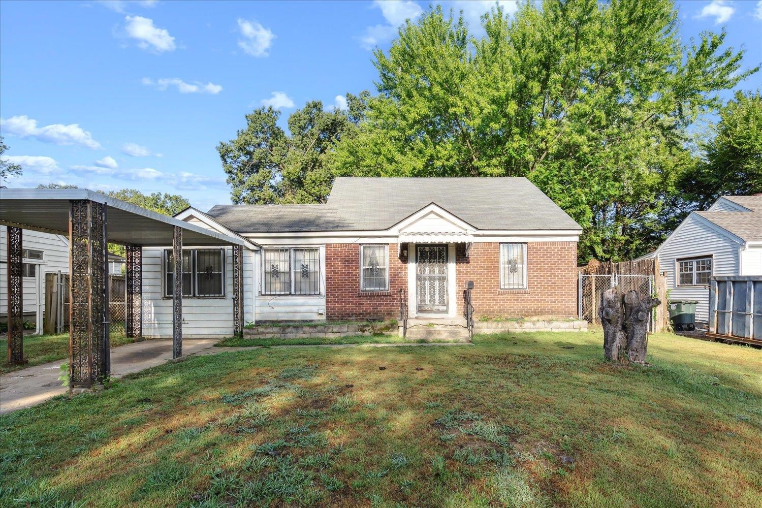 View of front of home featuring a front yard and a carport