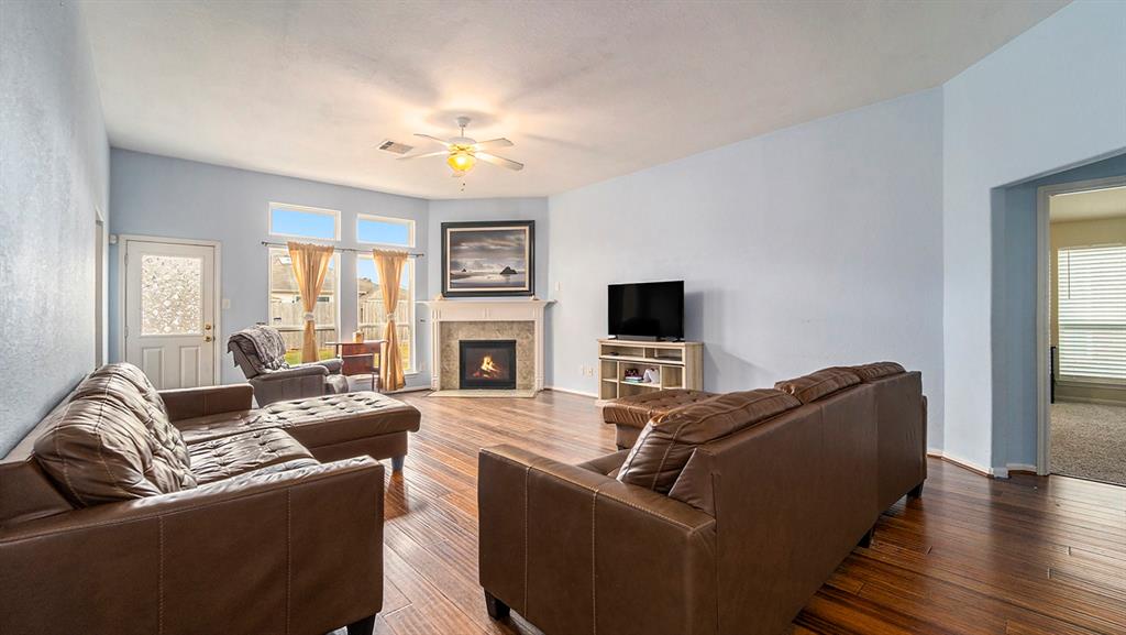 a living room with furniture a fireplace and a flat screen tv