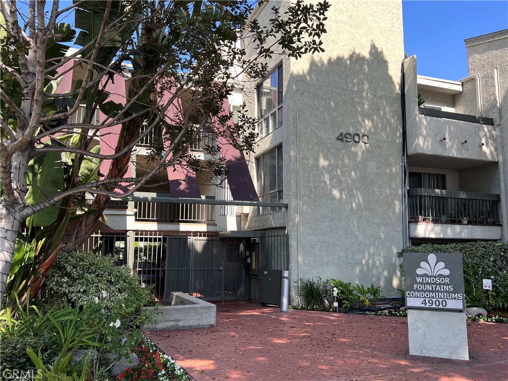 a front view of a building with a tree