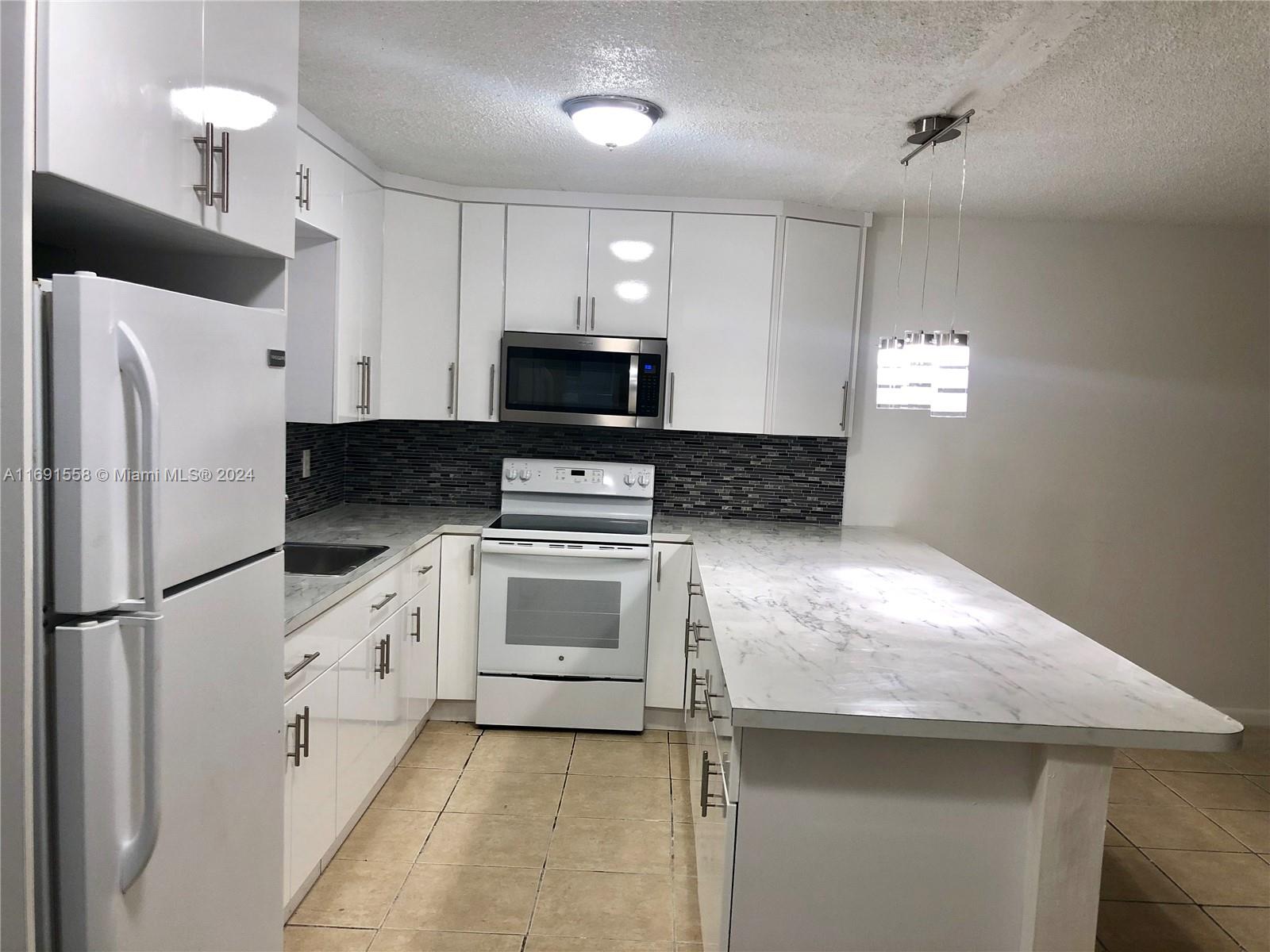 a kitchen with stainless steel appliances a refrigerator sink and microwave