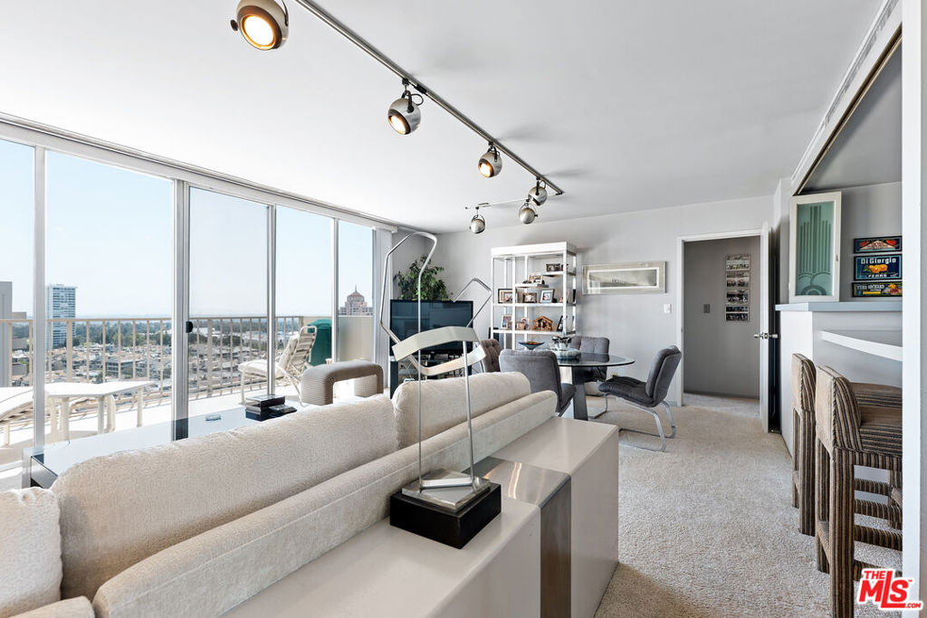 a living room with furniture large windows and a fireplace