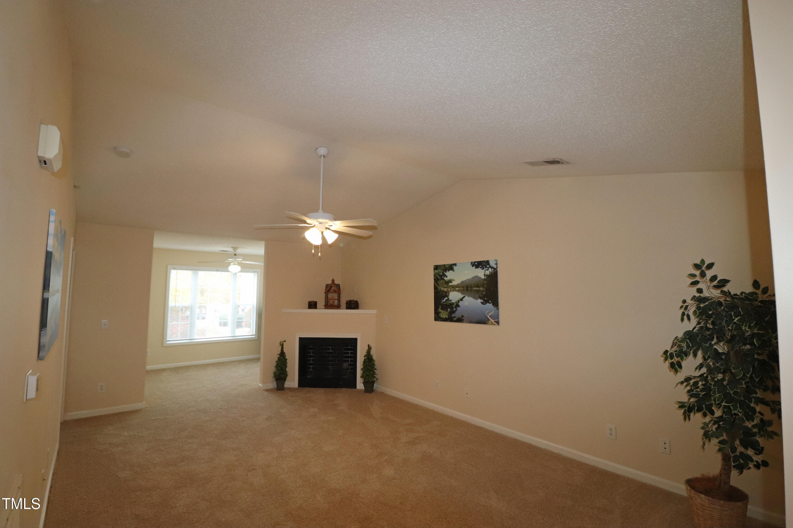 en empty room with windows and fireplace