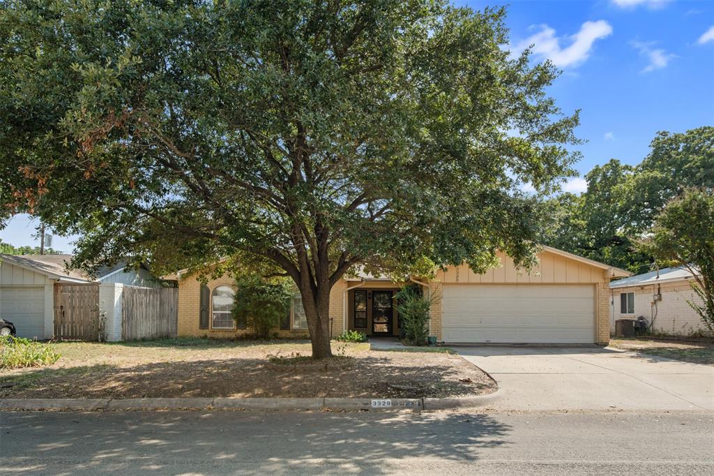 a front view of a house with a tree and a yard