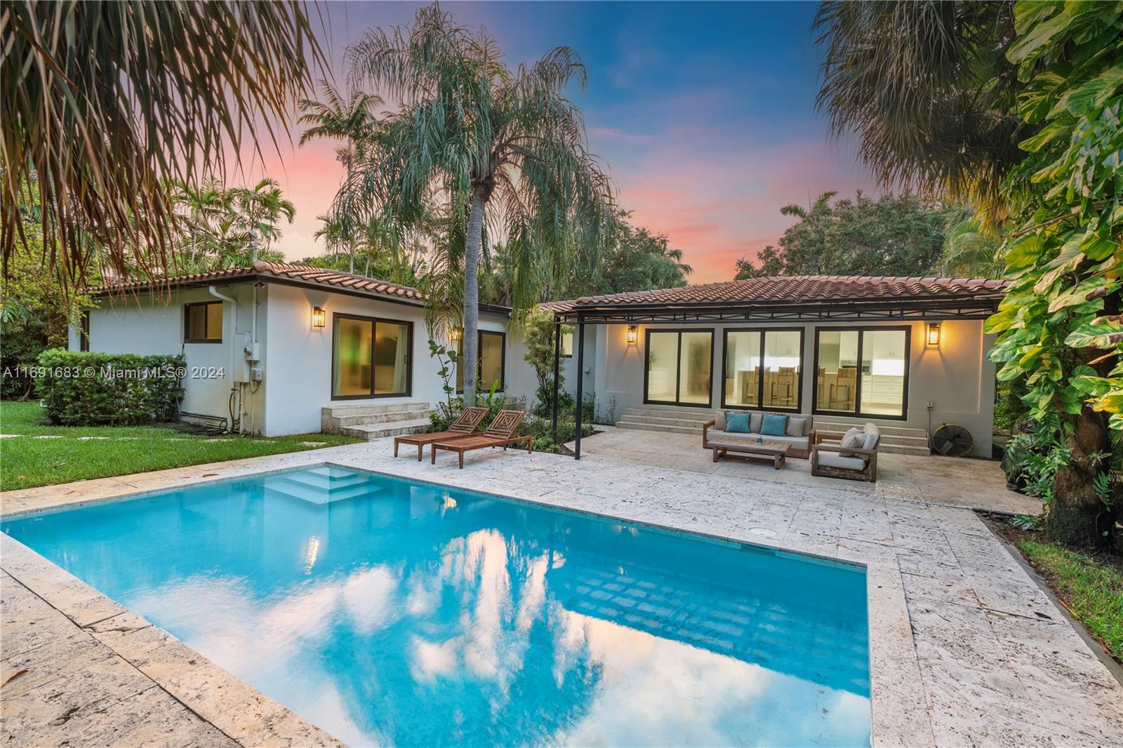 a view of a house with swimming pool and sitting area