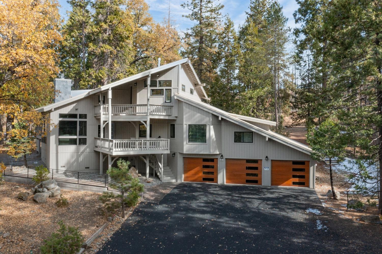 a front view of house with yard and trees in the background