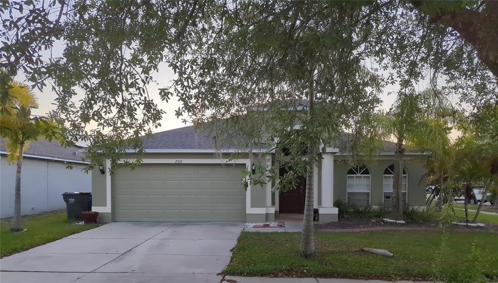 front view of a house with a yard and an trees