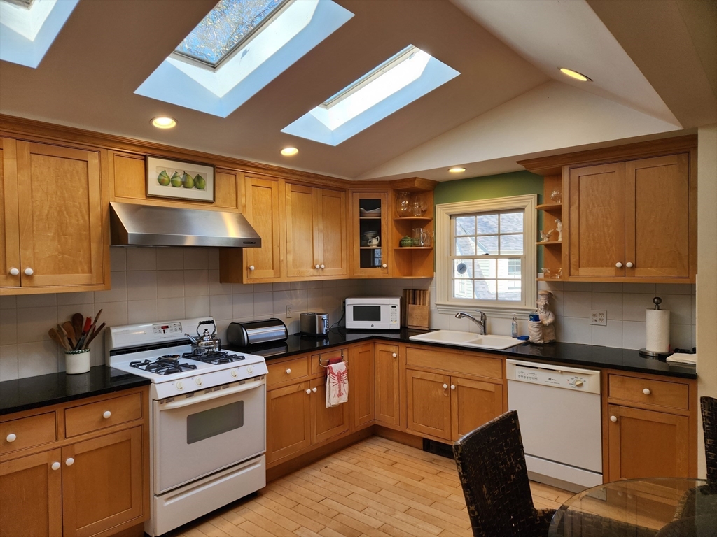 a kitchen with stainless steel appliances granite countertop a sink a stove and cabinets