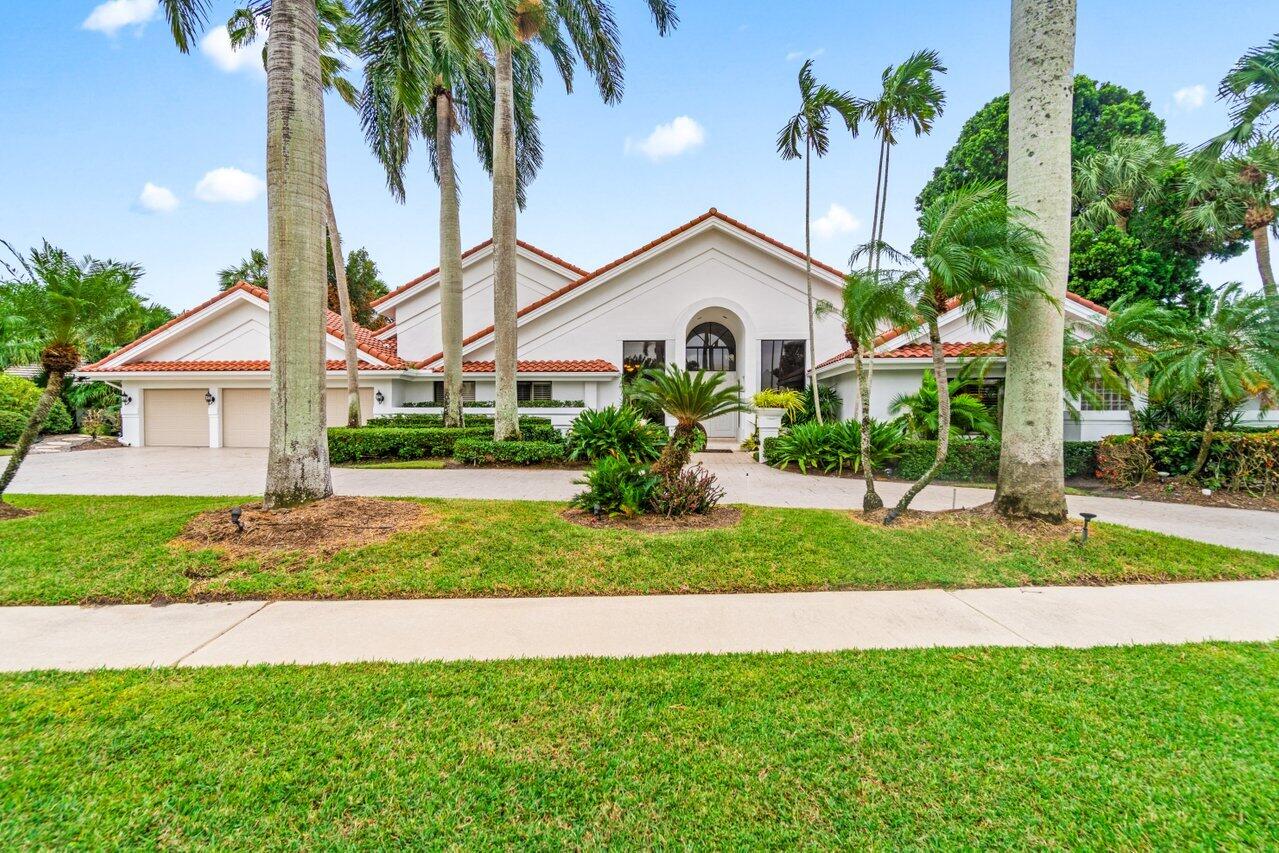 a front view of a house with a yard and potted plants