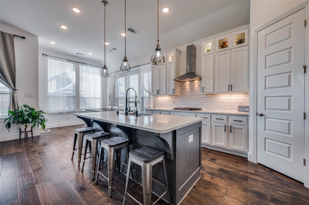 a kitchen with kitchen island granite countertop a sink cabinets and wooden floor