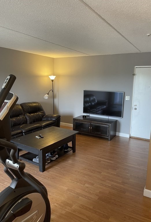 a living room with furniture flat screen tv and gym equipment