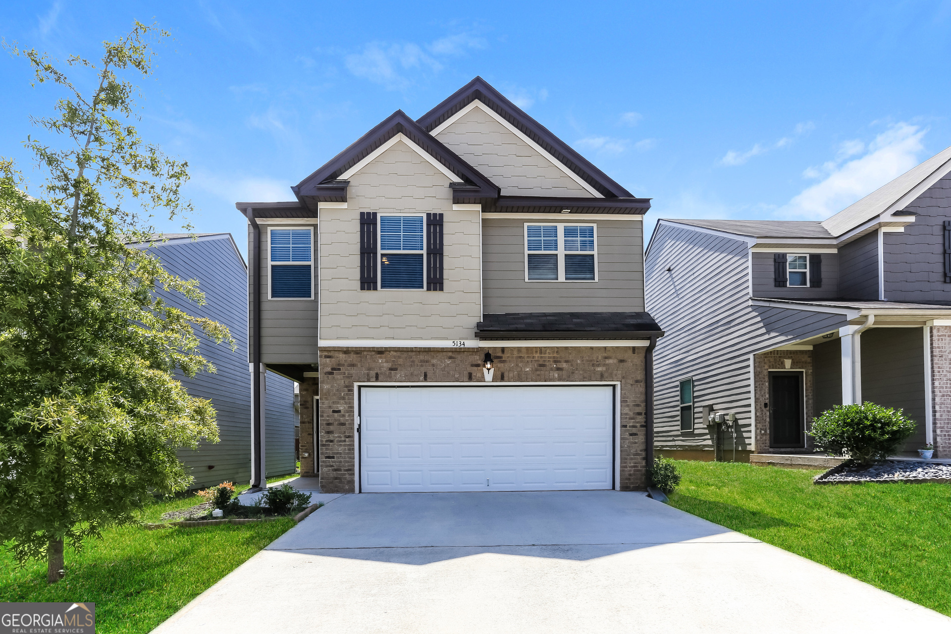 a front view of a house with a yard and garage