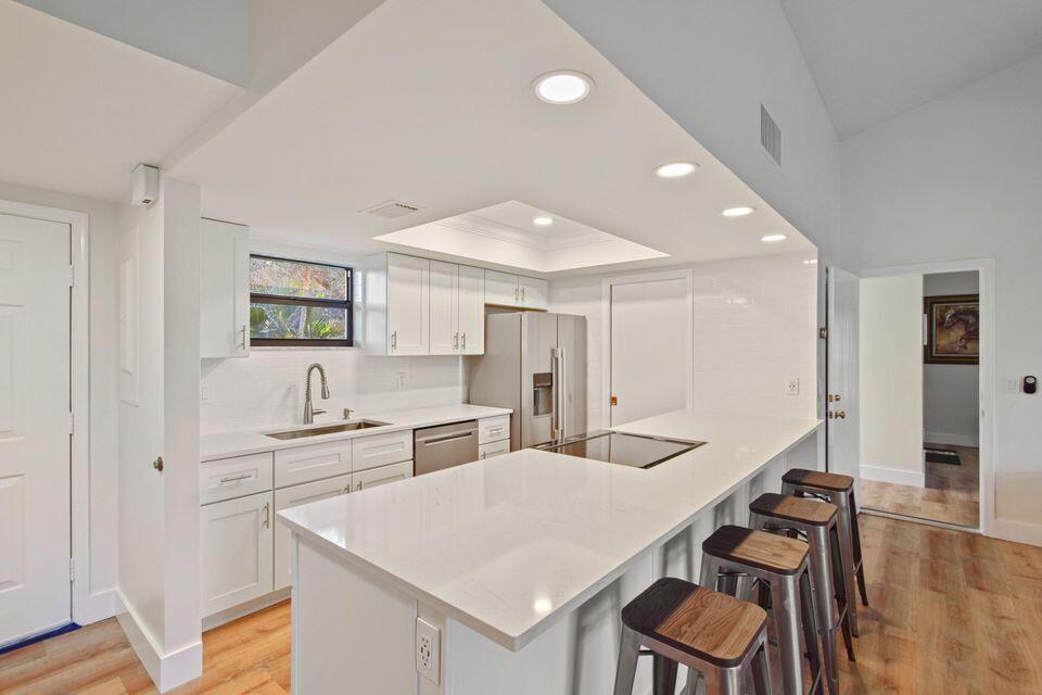 a large white kitchen with a table and chairs