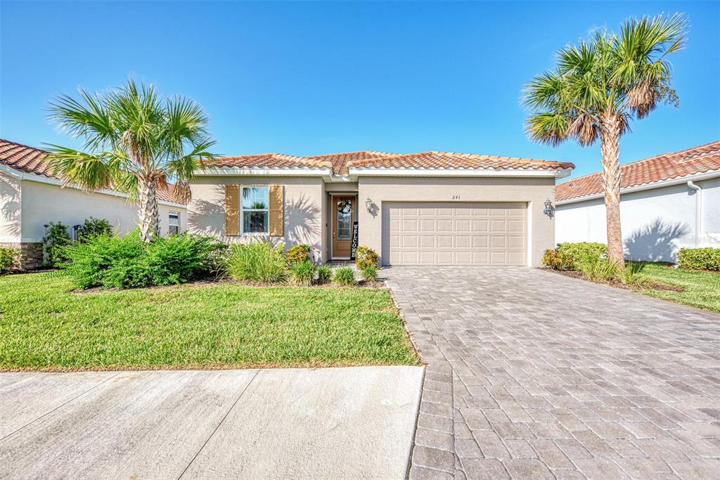 a front view of a house with a garden and palm trees