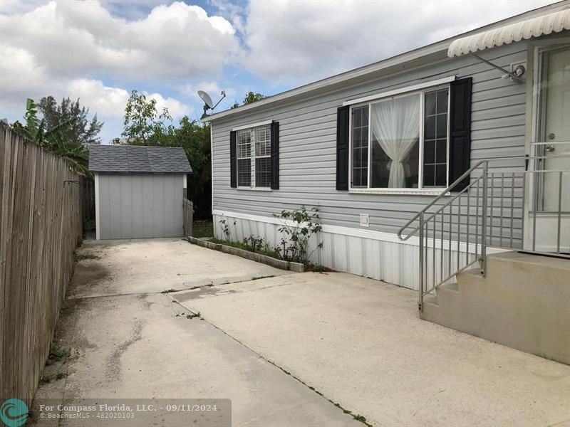 a view of house with small yard and wooden fence