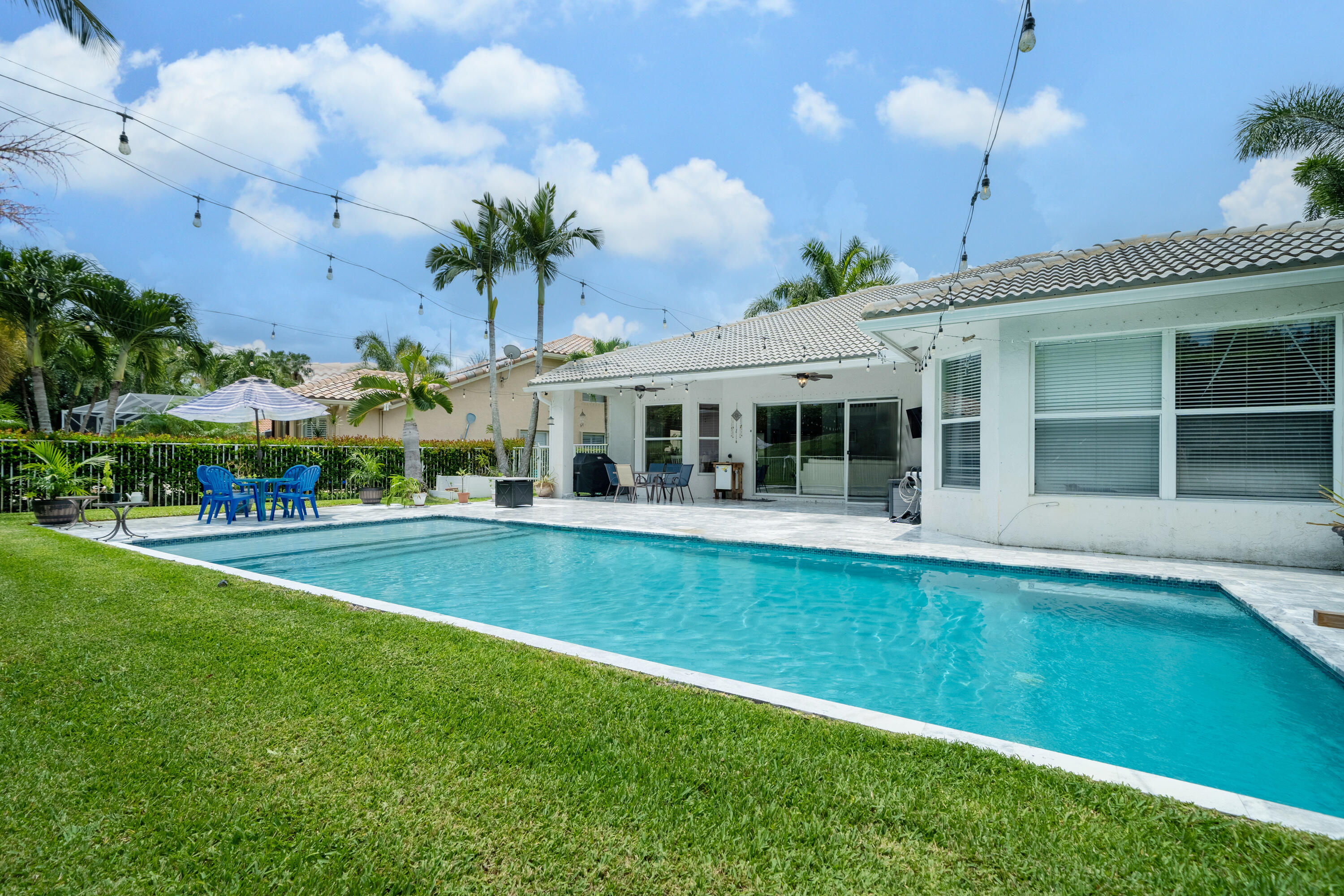 a view of a house with a swimming pool and a yard