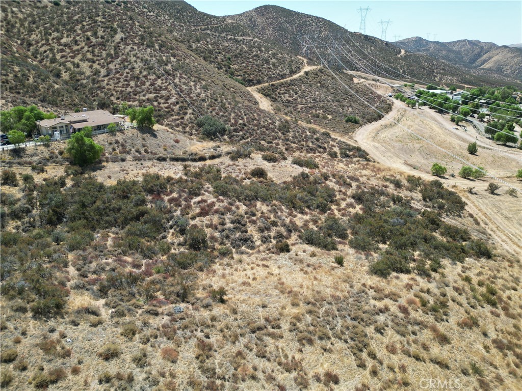 a view of a dry yard with mountains in the background