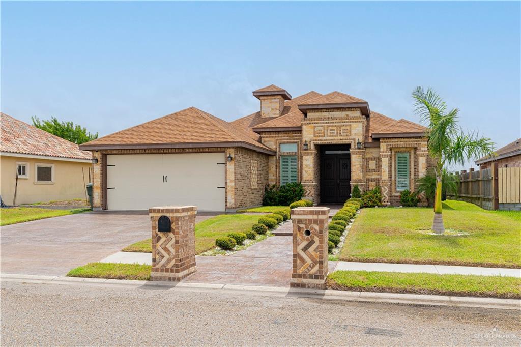 a front view of house with yard and trees around