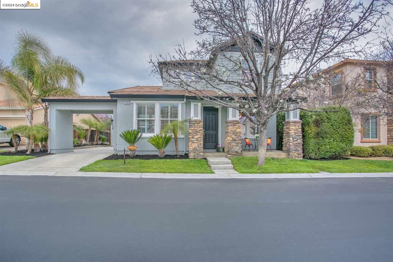 a view of a house next to a big yard and palm trees