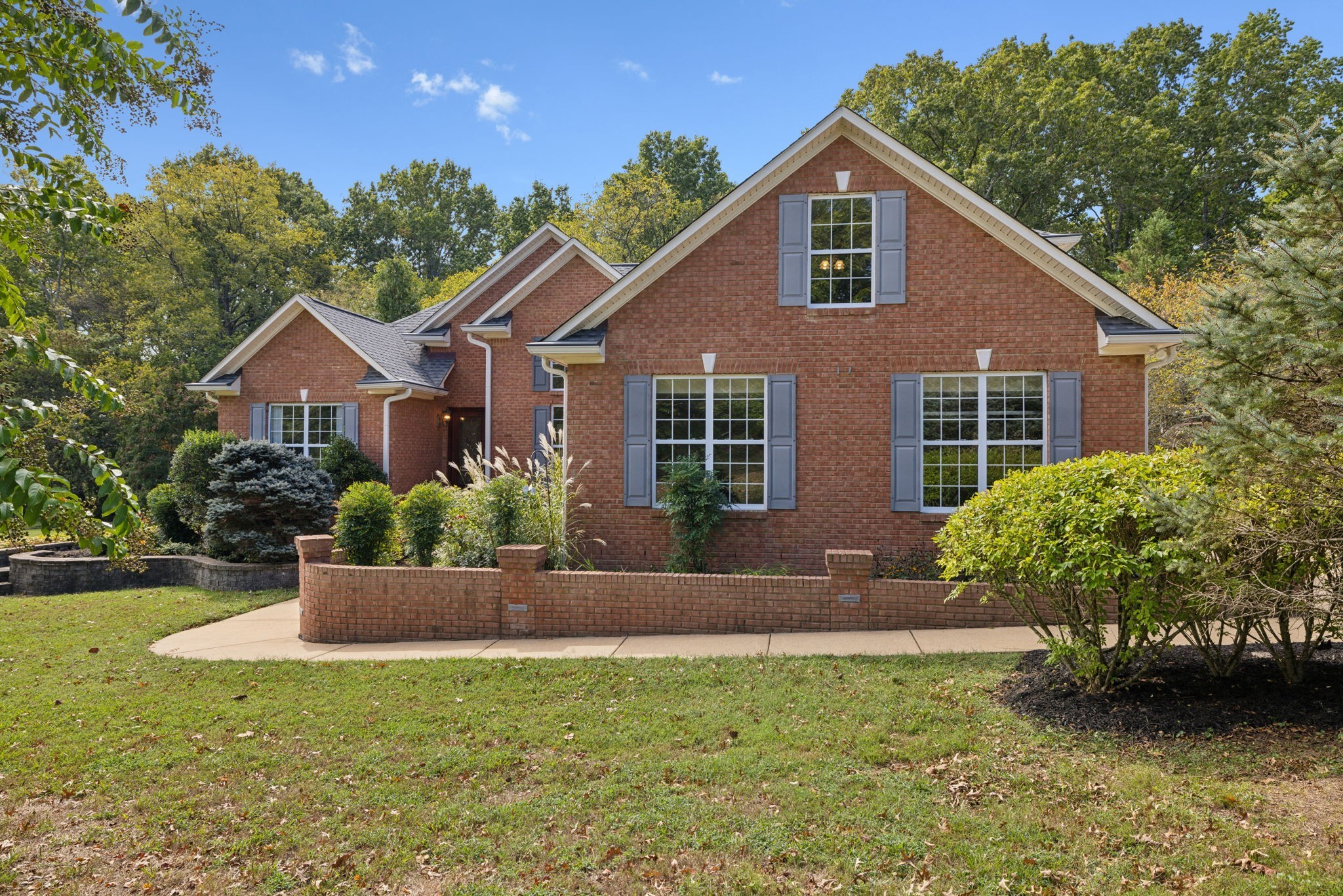 a front view of a house with a yard and potted plants