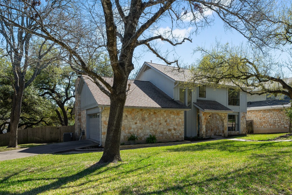 Welcome home! Manicured front yard with trees