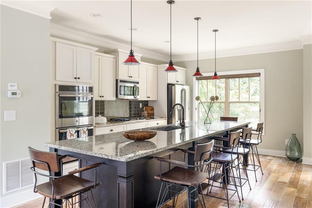 a view of kitchen with kitchen island stainless steel appliances furniture dining table and chairs