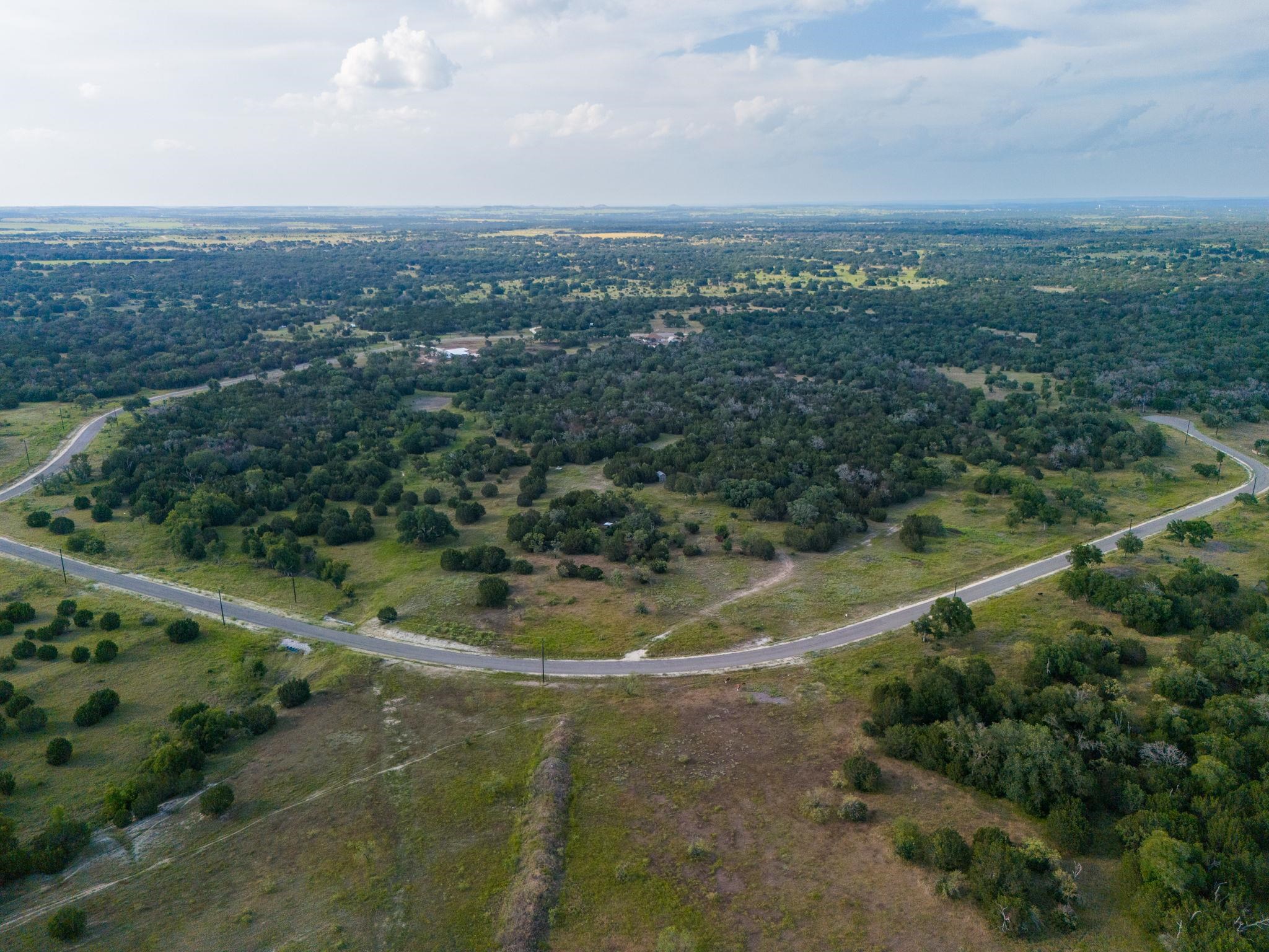 an aerial view of residential houses with outdoor space and trees