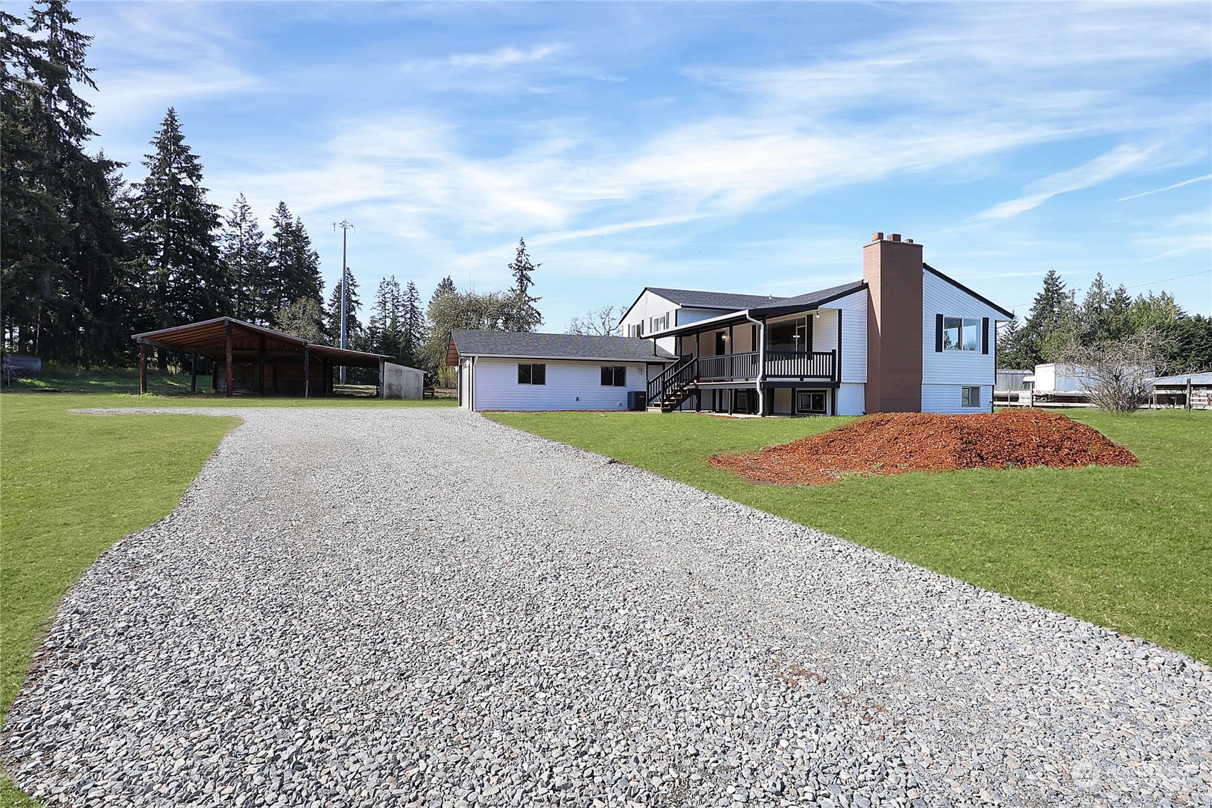 a view of a house with a big yard and large trees