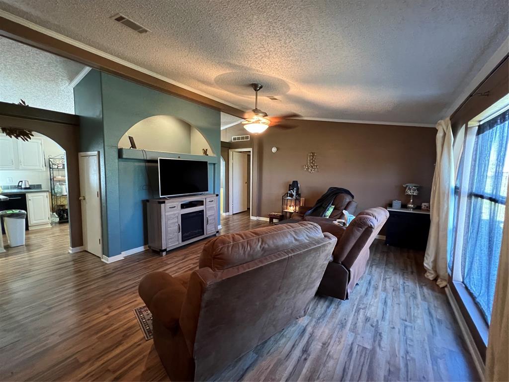 a living room with furniture a flat screen tv and a wooden floor