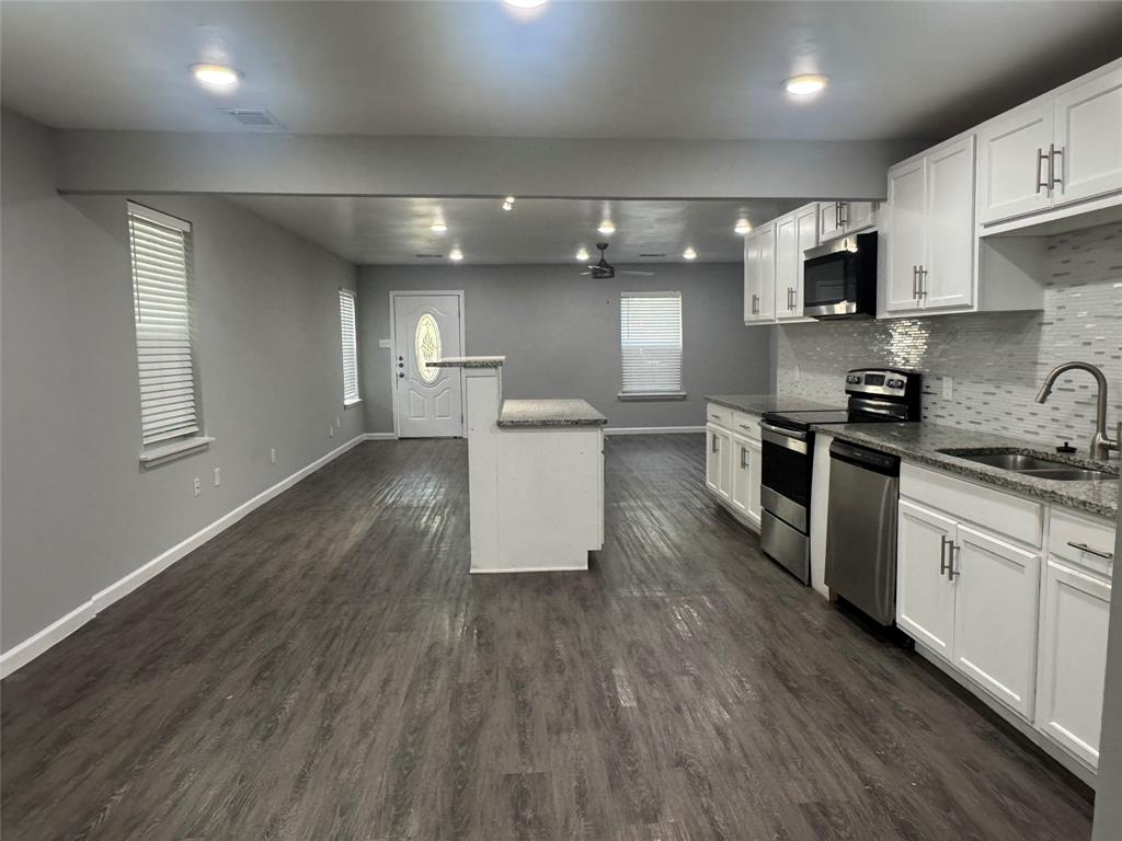 a kitchen with a sink a microwave and cabinets