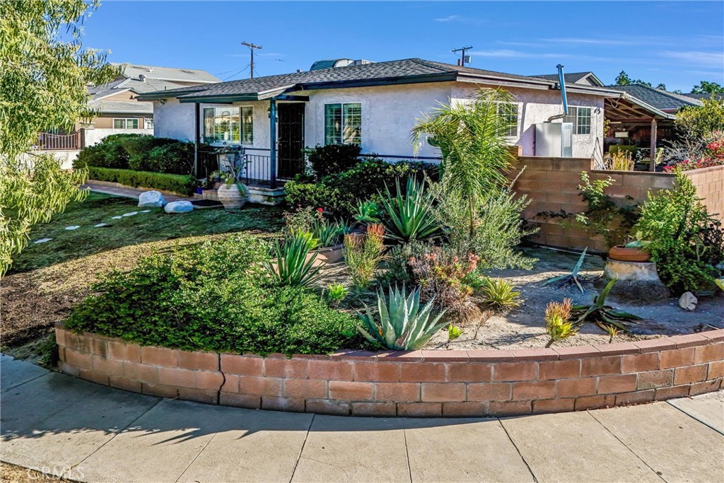 a front view of a house with a yard and potted plants