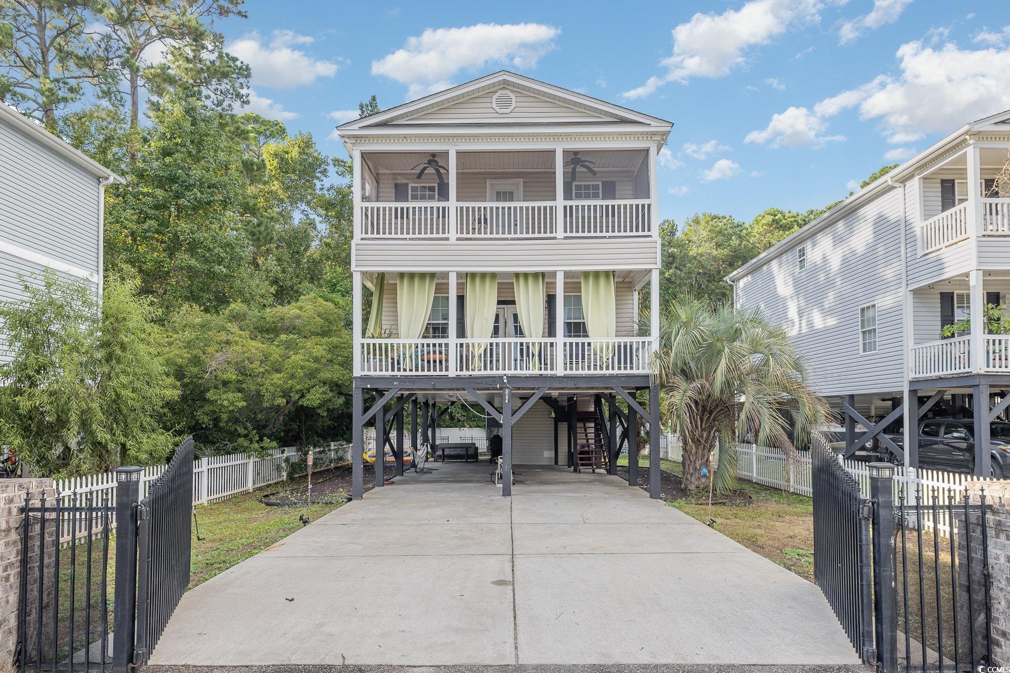 Beach home with a balcony, covered porch, and a ca