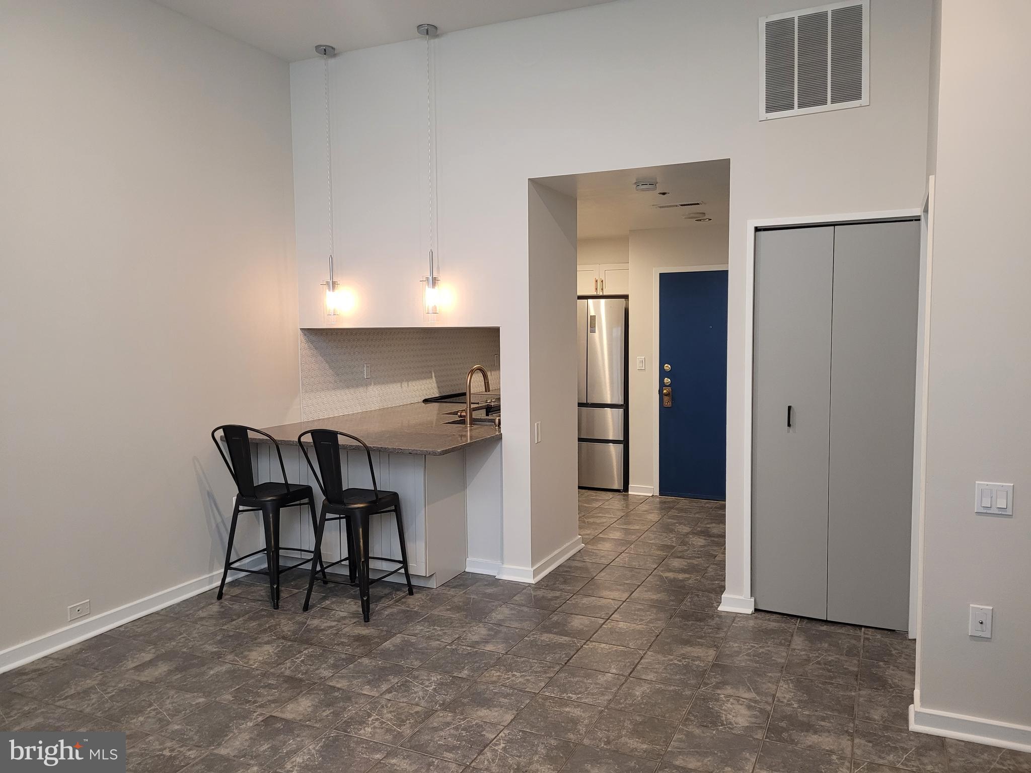 a view of kitchen with furniture and refrigerator