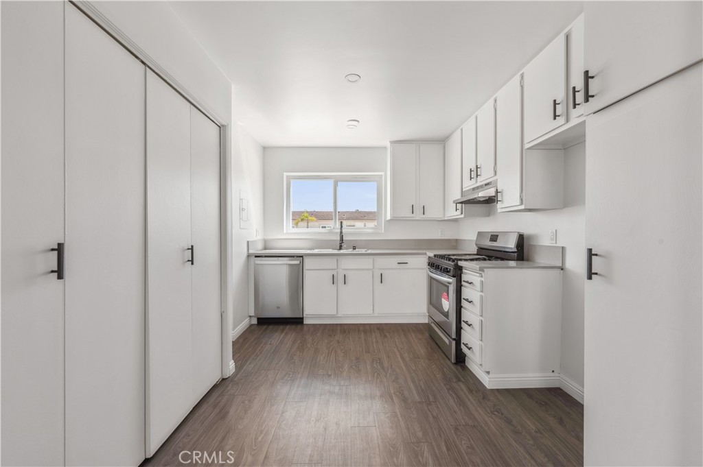 a kitchen with cabinets stainless steel appliances a sink and a counter space