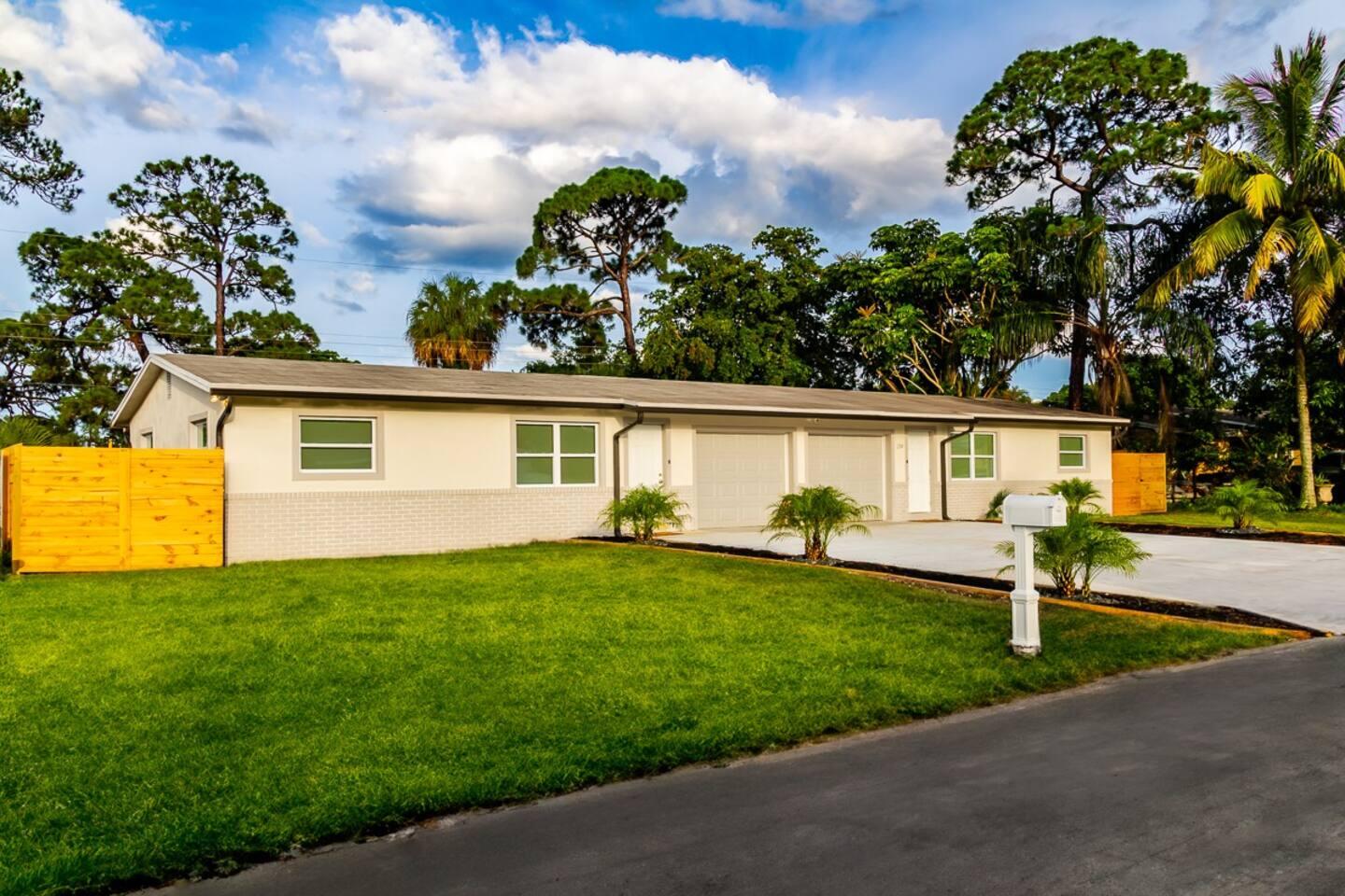 a view of a house with backyard and a tree