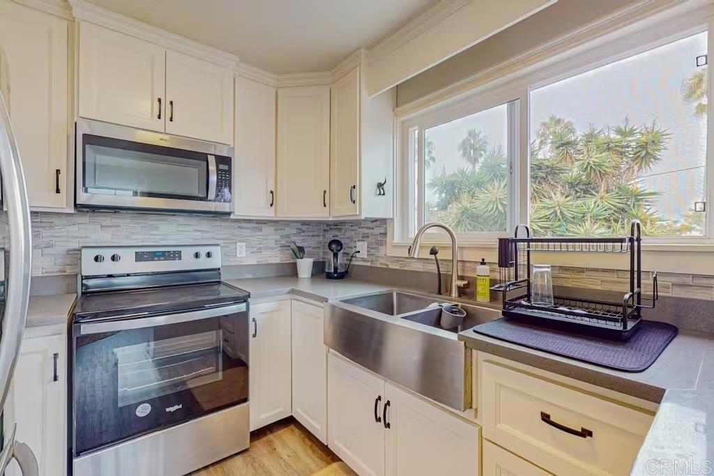 a kitchen with appliances a sink and cabinets