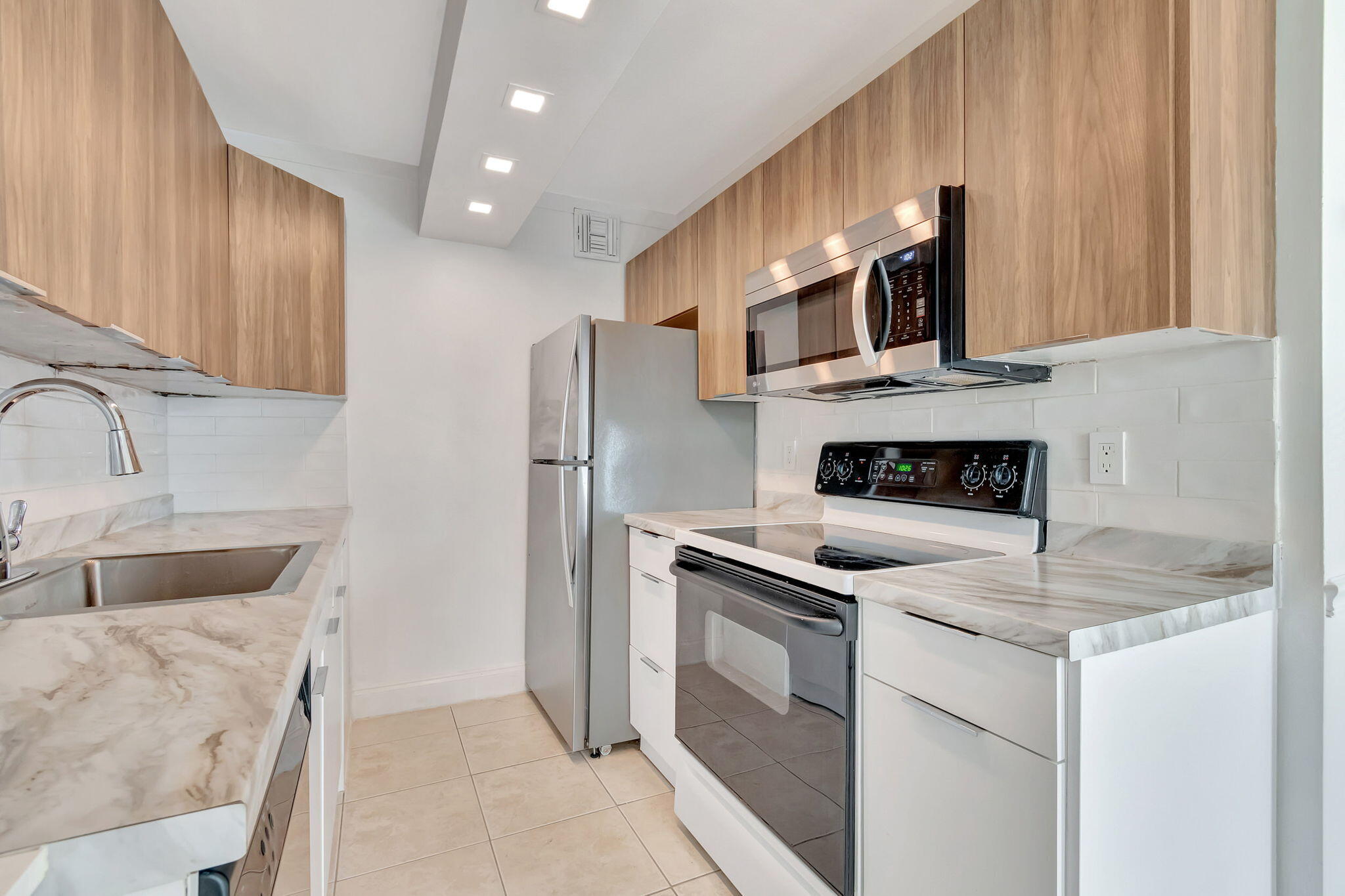 a kitchen with stainless steel appliances granite countertop a sink a stove and a refrigerator