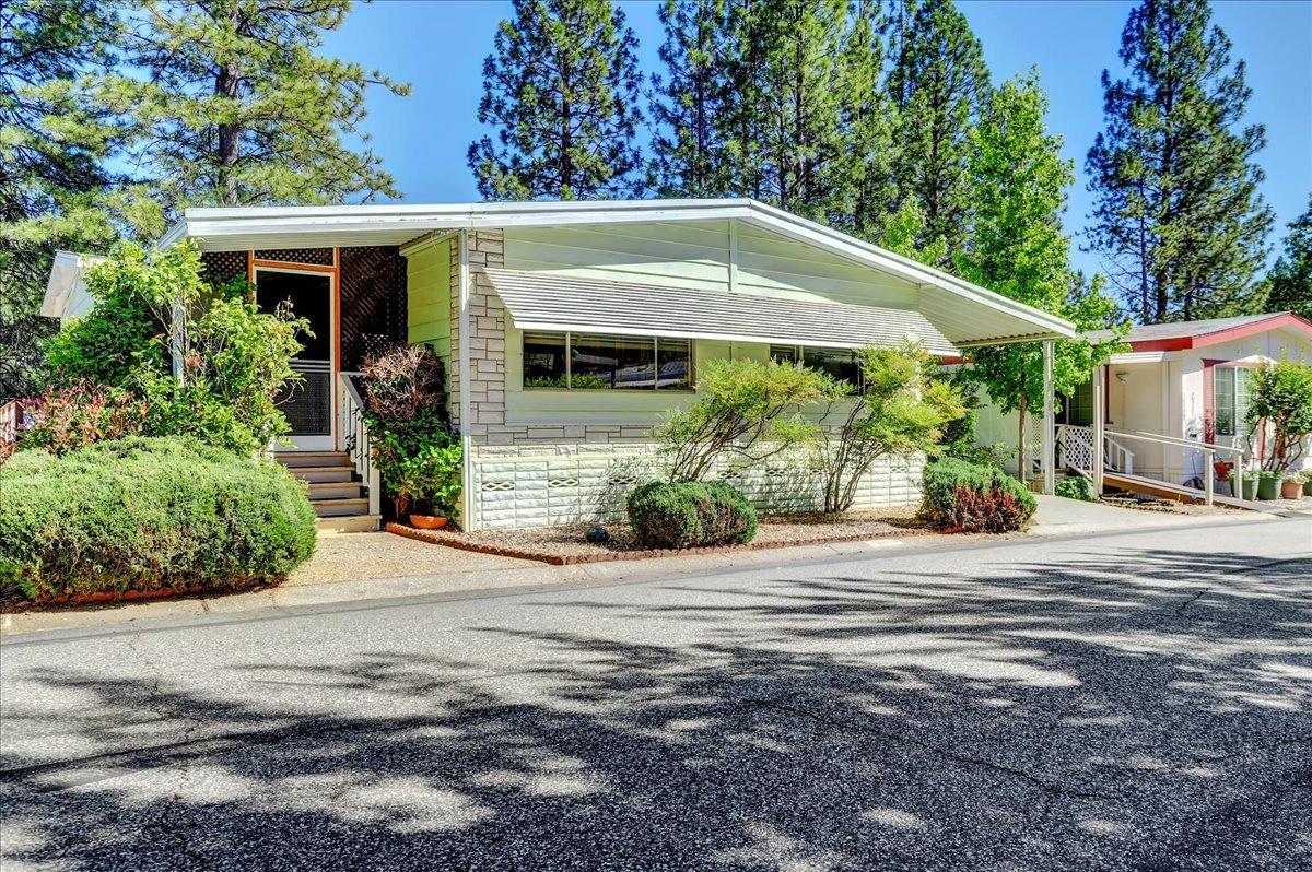 a front view of a house with a yard and potted plants