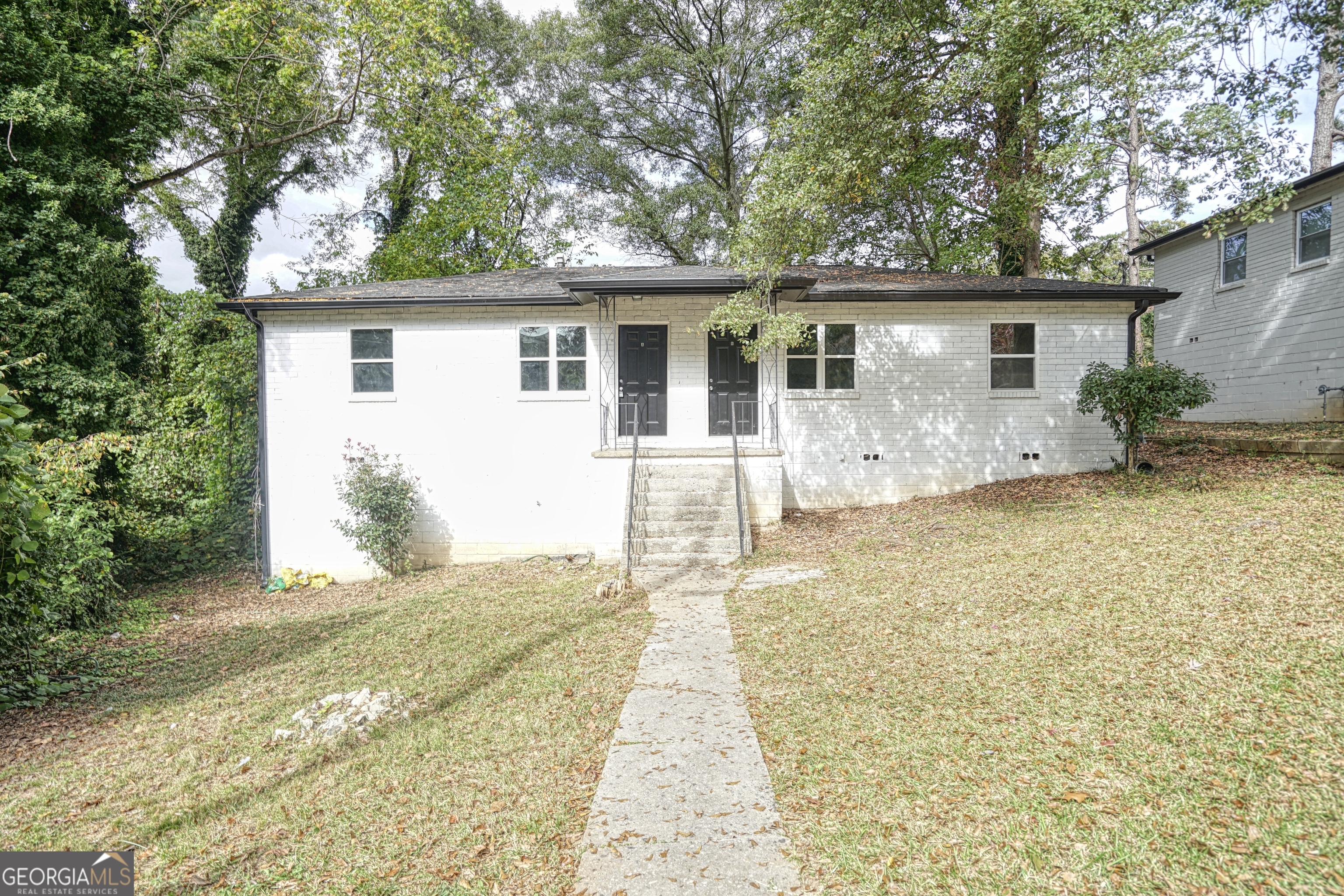 a front view of a house with a yard and potted plants