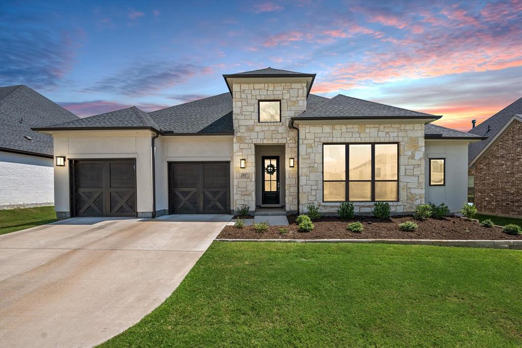 a front view of a house with a yard and garage