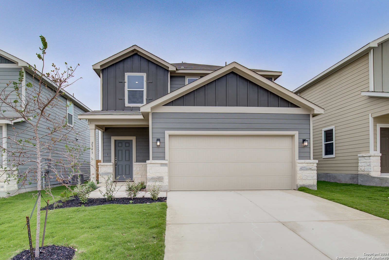 a front view of a house with a yard and garage