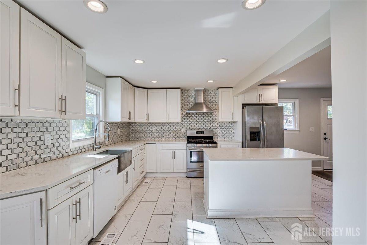 a large kitchen with stainless steel appliances and white cabinets