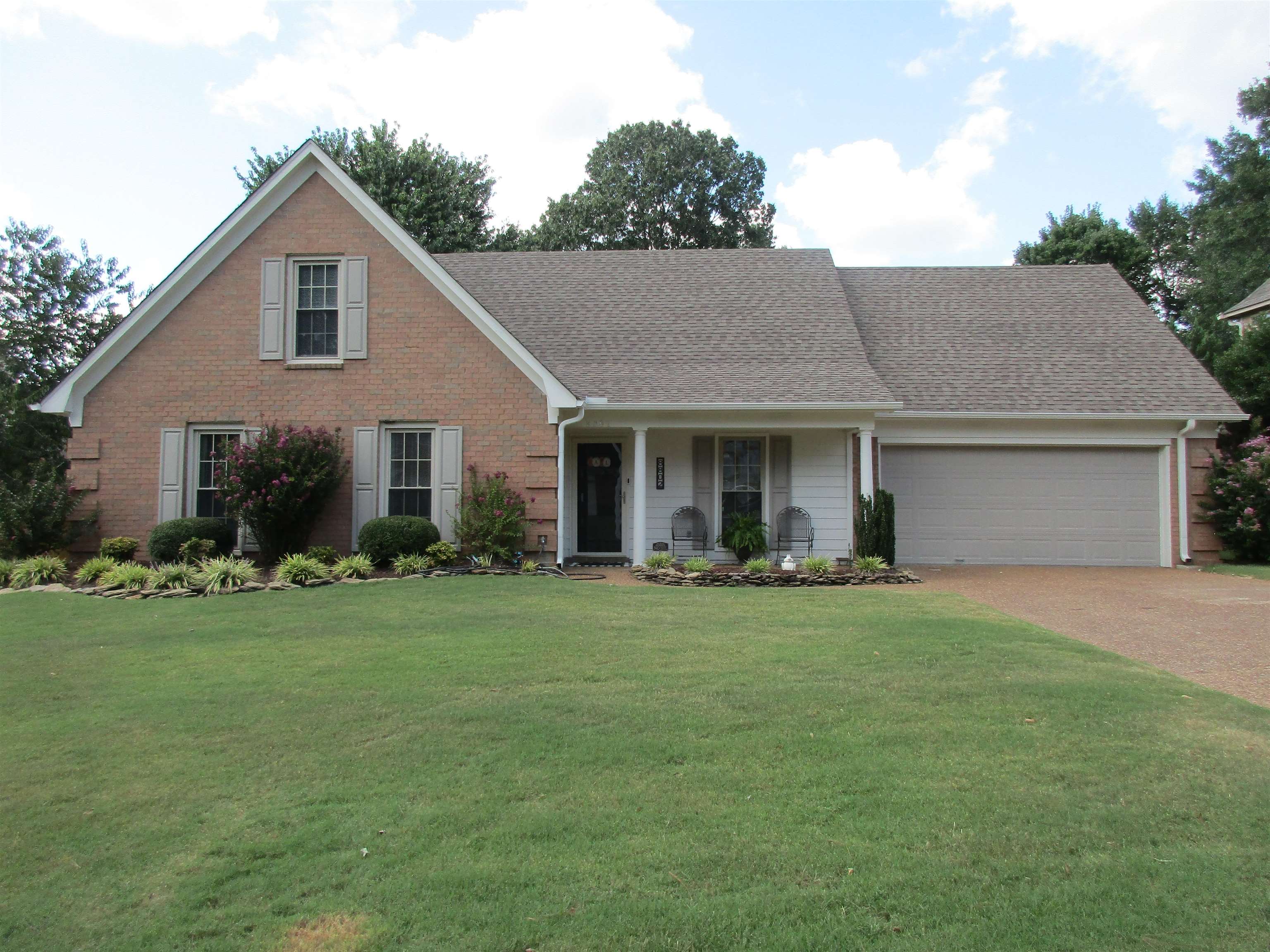 a front view of a house with a garden and yard