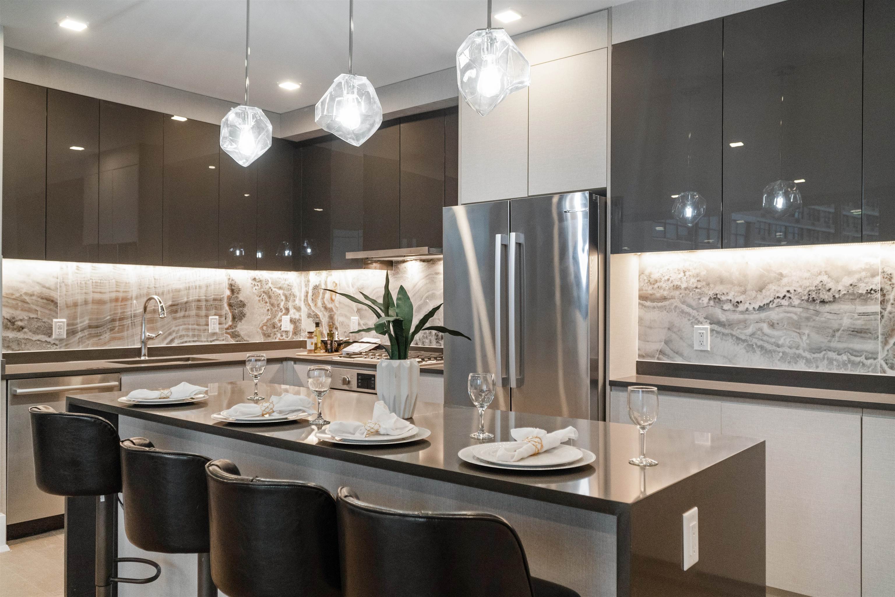 a kitchen with a sink a refrigerator and chairs