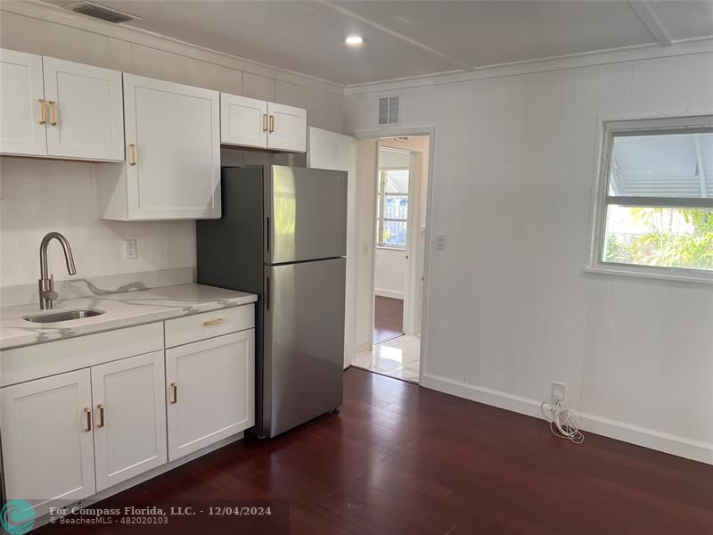 a kitchen with a refrigerator sink and cabinets